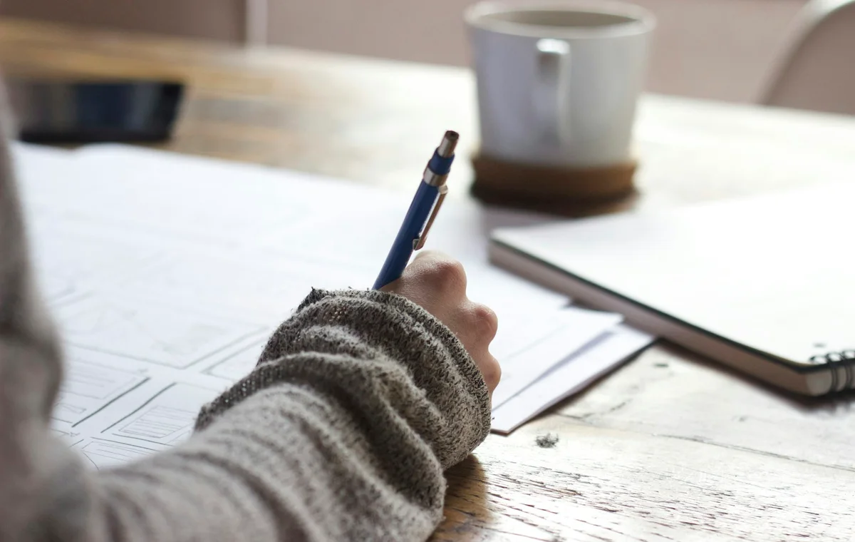 Étudiant en révision avec cahier et ordinateur